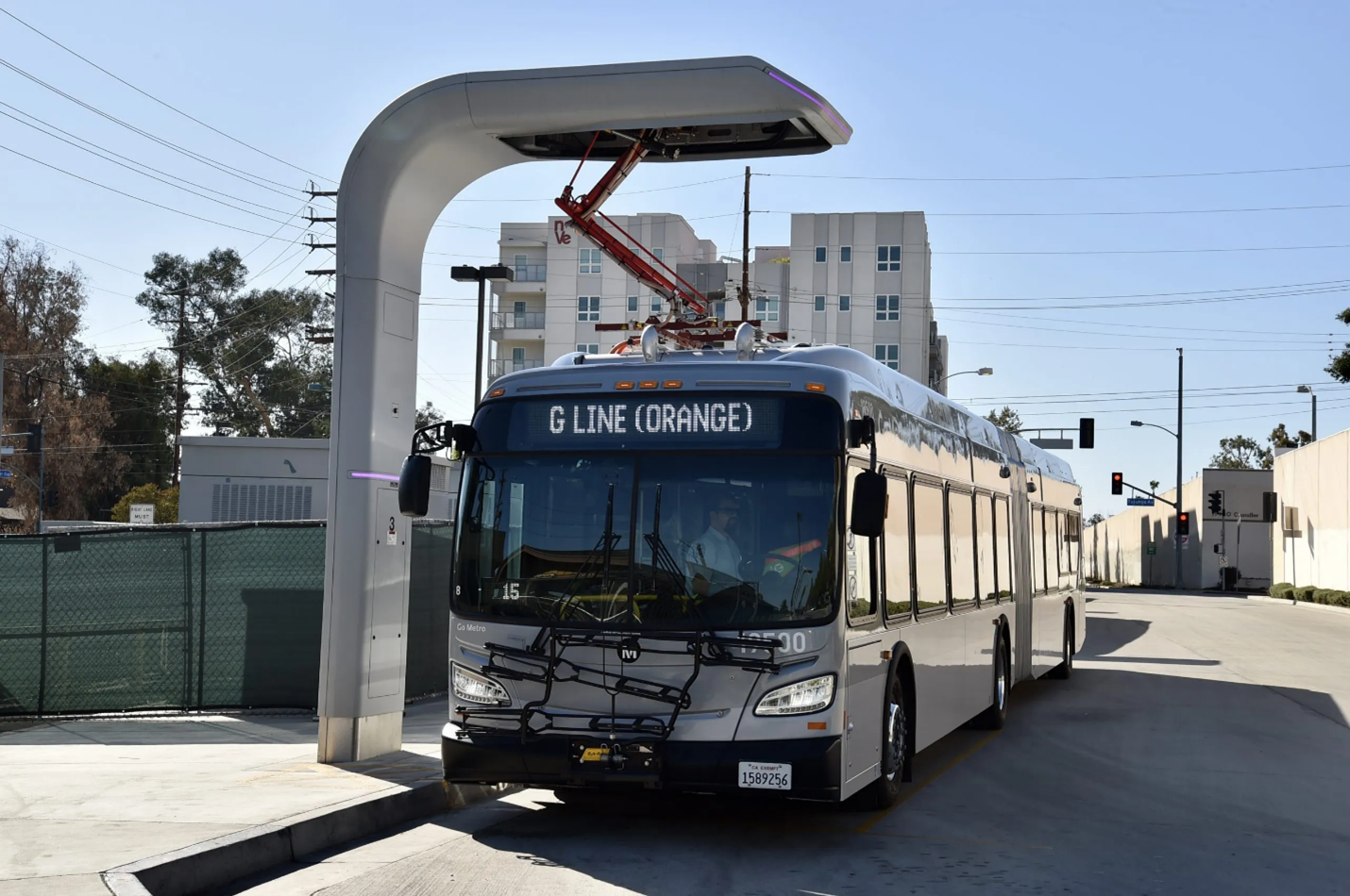 Silver bus parked at a Metro G Line (Orange) station.