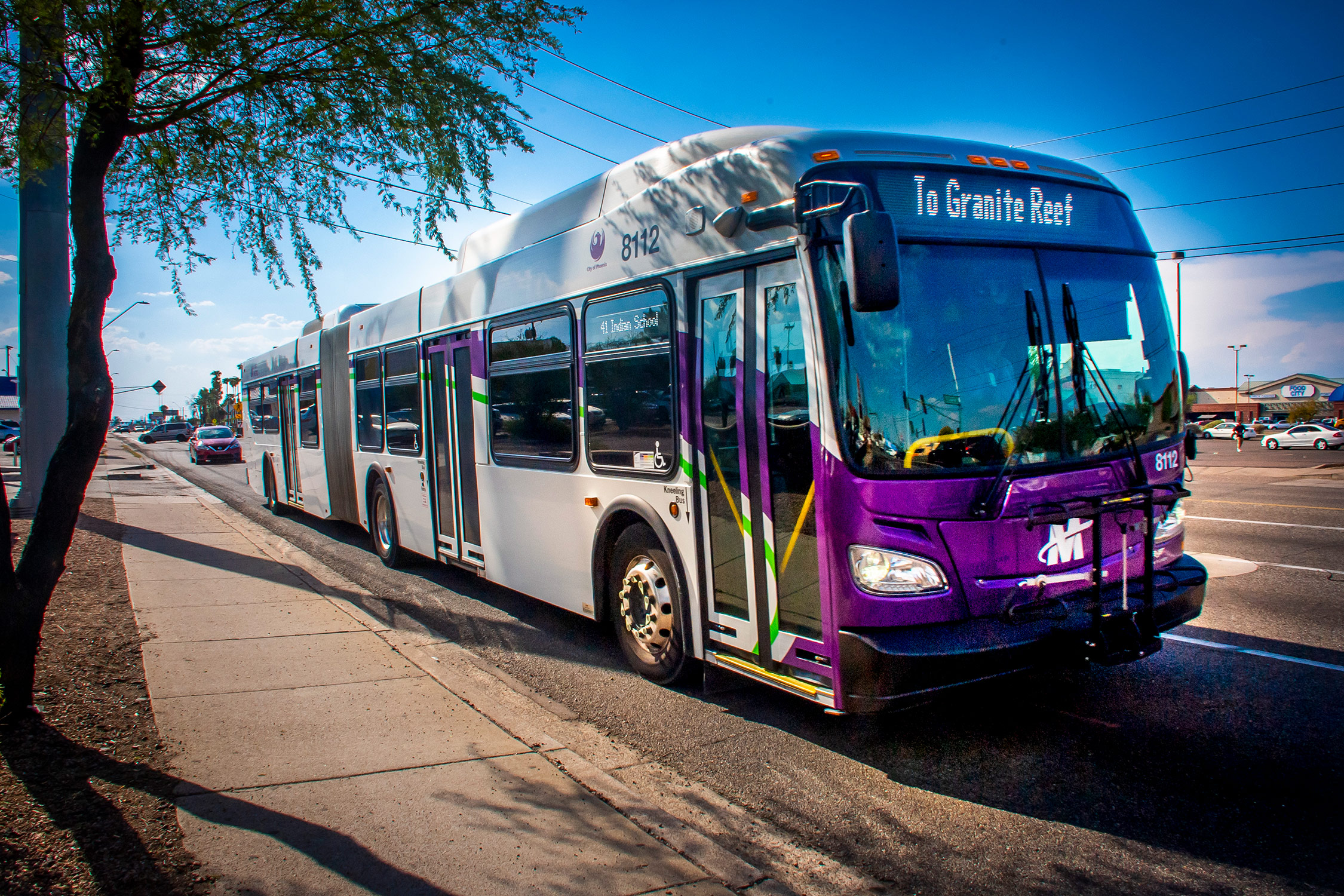 A purple articulated bus on a Phoenix street